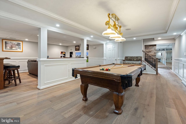 rec room with pool table, light wood-style floors, ornamental molding, and a wainscoted wall