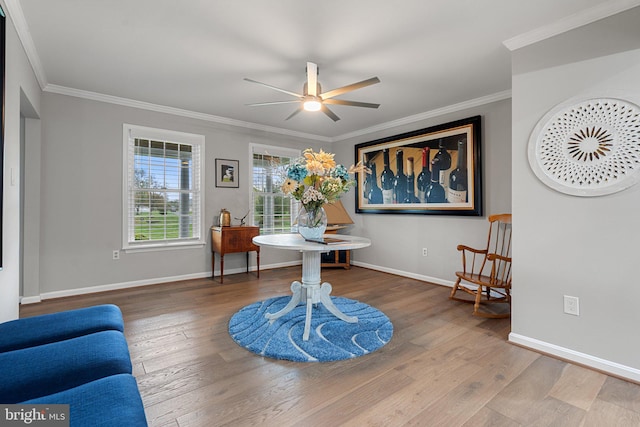 living area featuring ornamental molding, baseboards, a ceiling fan, and hardwood / wood-style flooring