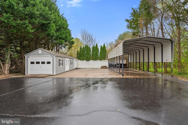 detached garage with a detached carport and fence