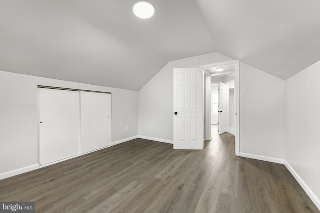 additional living space with wood finished floors, baseboards, and lofted ceiling