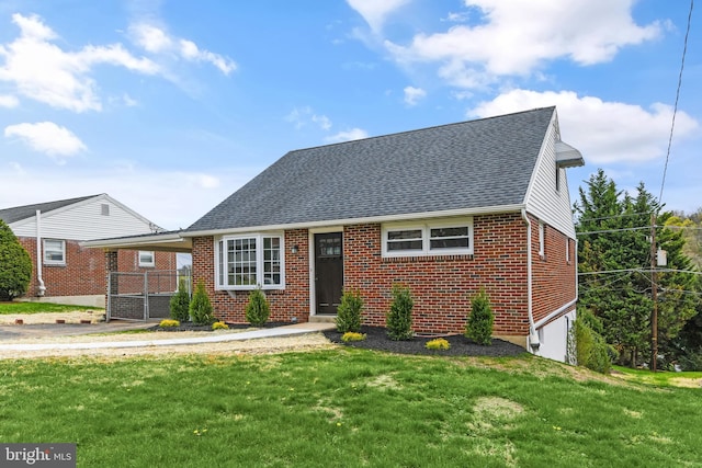 view of front of property featuring roof with shingles, a front yard, and brick siding