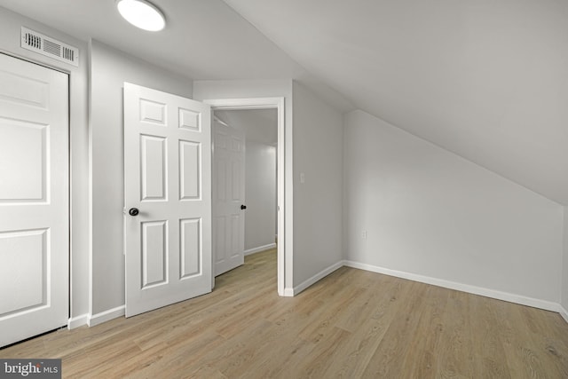 bonus room with visible vents, baseboards, light wood finished floors, and vaulted ceiling