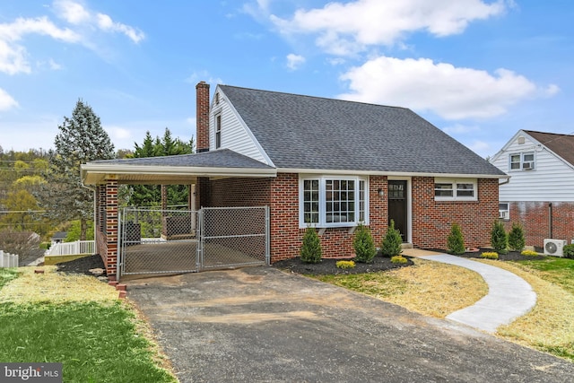 view of front of house featuring aphalt driveway, brick siding, a carport, and fence