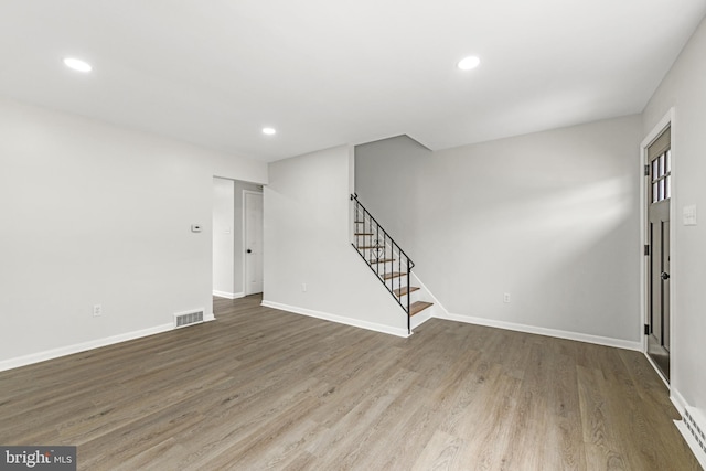 interior space featuring baseboards, recessed lighting, stairs, visible vents, and wood finished floors