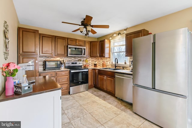 11 Solar Dr, New Providence, PA 17560 - kitchen with brown cabinets, decorative backsplash, stainless steel appliances, a sink, and ceiling fan