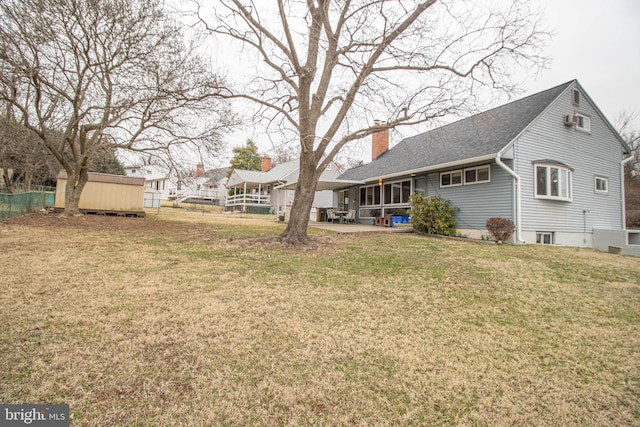 827 Crothers Ln, Rockville, MD 20852 - rear view of property featuring a chimney, fence, an outdoor structure, and a yard