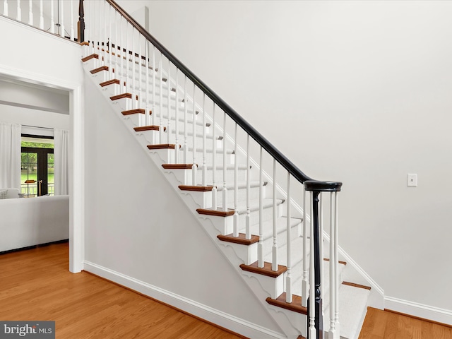 stairs with wood finished floors and baseboards