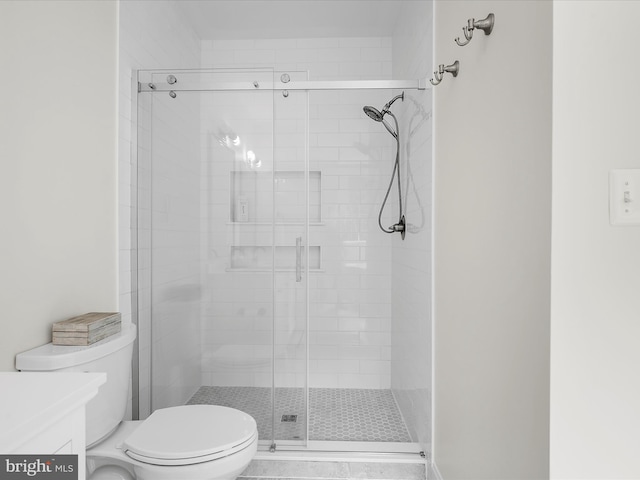bathroom with vanity, toilet, and a shower stall