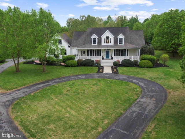 new england style home with roof with shingles, a porch, a front lawn, and curved driveway