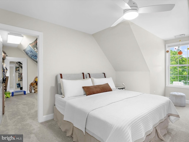bedroom with light colored carpet, a ceiling fan, vaulted ceiling, and baseboards