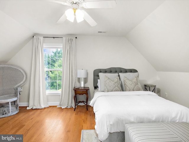 bedroom with visible vents, ceiling fan, baseboards, vaulted ceiling, and wood finished floors