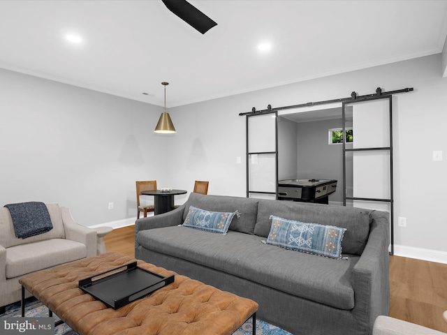living room featuring baseboards, a barn door, wood finished floors, and recessed lighting