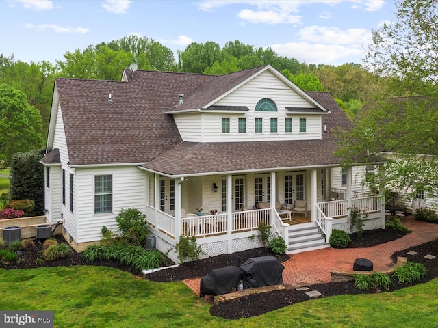 back of property featuring french doors, a shingled roof, and a lawn