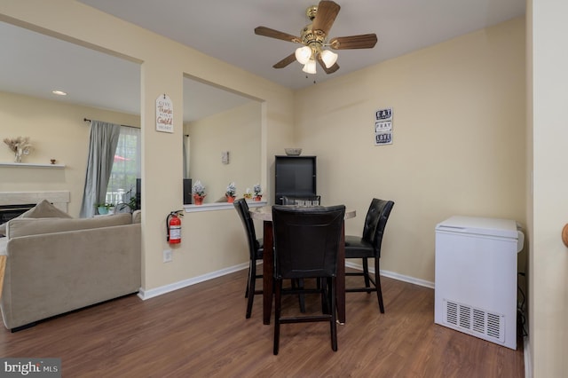 dining area featuring baseboards, wood finished floors, and ceiling fan