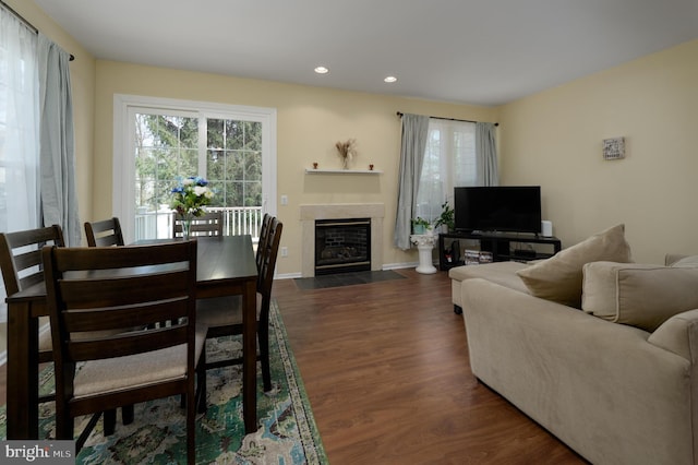 living room with recessed lighting, dark wood finished floors, a fireplace with flush hearth, and baseboards