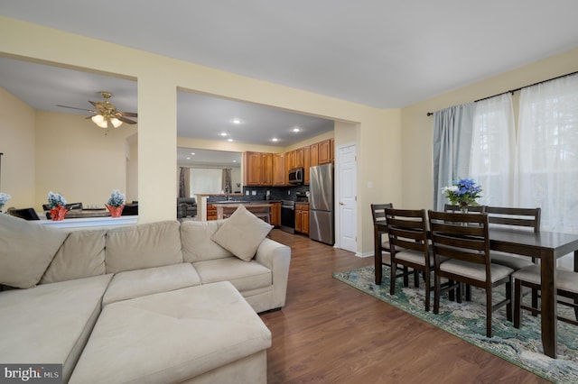 living area featuring ceiling fan, baseboards, dark wood-style flooring, and recessed lighting