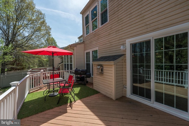 wooden terrace with fence, outdoor dining area, and area for grilling