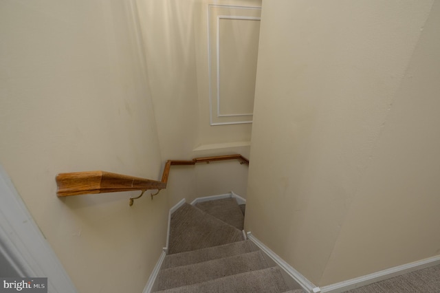 stairs featuring baseboards and carpet