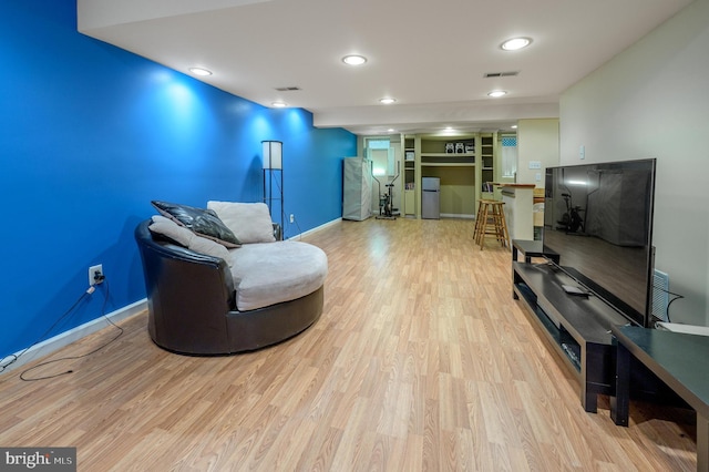 living area featuring visible vents, baseboards, wood finished floors, and recessed lighting