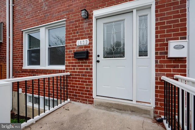 view of exterior entry featuring brick siding
