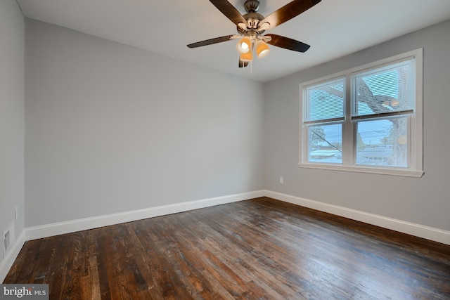 unfurnished room with baseboards, a ceiling fan, and dark wood finished floors