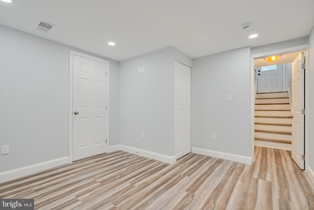 finished below grade area with baseboards, visible vents, light wood-style flooring, and recessed lighting