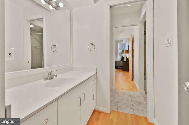 bathroom featuring vanity, baseboards, and wood finished floors