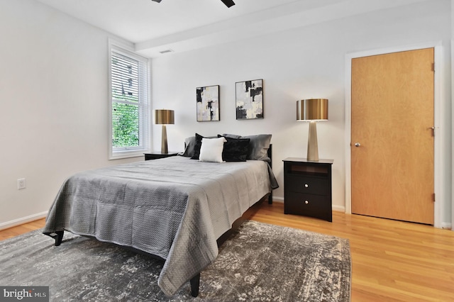 bedroom with baseboards, ceiling fan, and wood finished floors