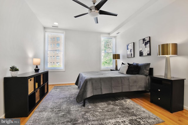 bedroom with baseboards, light wood finished floors, and ceiling fan