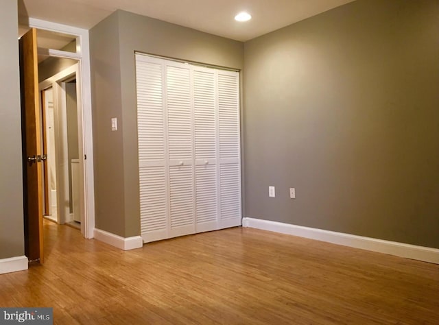 unfurnished bedroom featuring recessed lighting, baseboards, wood finished floors, and a closet