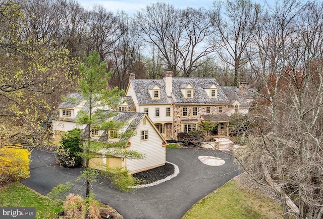 view of front facade with driveway and a chimney