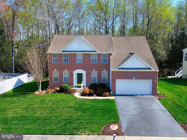 view of front of house featuring concrete driveway, fence, a front lawn, and brick siding