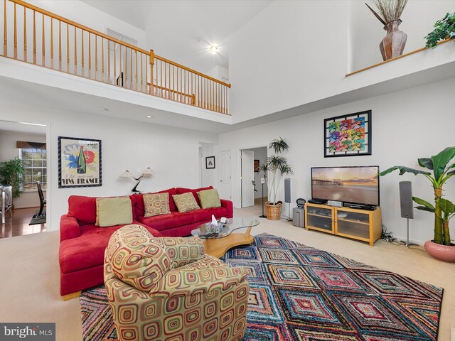 living room with carpet floors and a towering ceiling