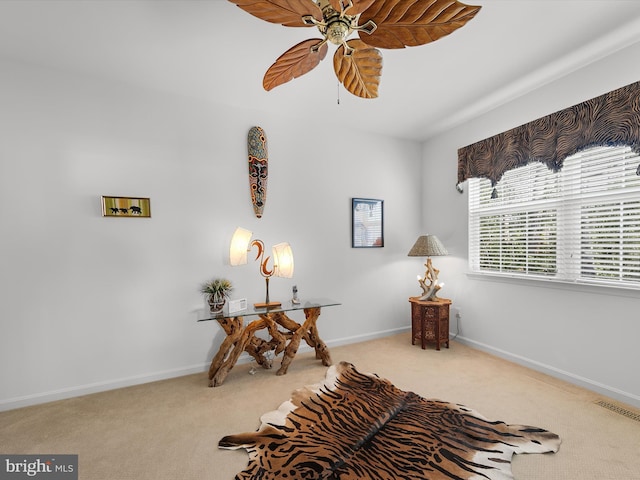 living area featuring visible vents, carpet floors, baseboards, and ceiling fan