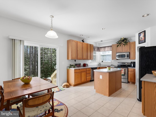 kitchen with recessed lighting, a center island, light countertops, stainless steel appliances, and a sink