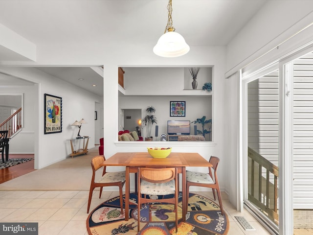 dining area featuring stairway, visible vents, and light tile patterned floors