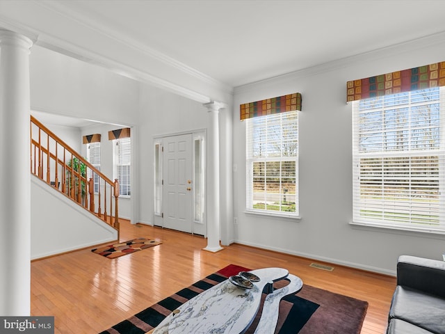 entrance foyer featuring ornamental molding, visible vents, decorative columns, and hardwood / wood-style floors