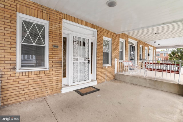 property entrance with brick siding and covered porch