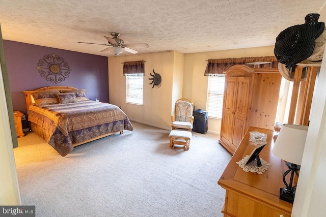 bedroom featuring ceiling fan, carpet, baseboards, and a textured ceiling