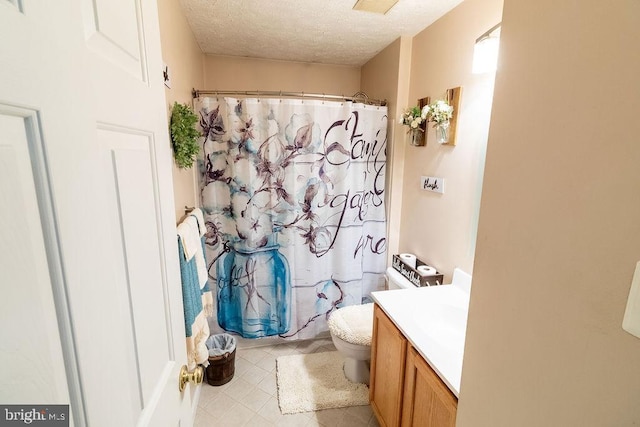 full bathroom featuring a textured ceiling, vanity, tile patterned flooring, toilet, and a shower with shower curtain
