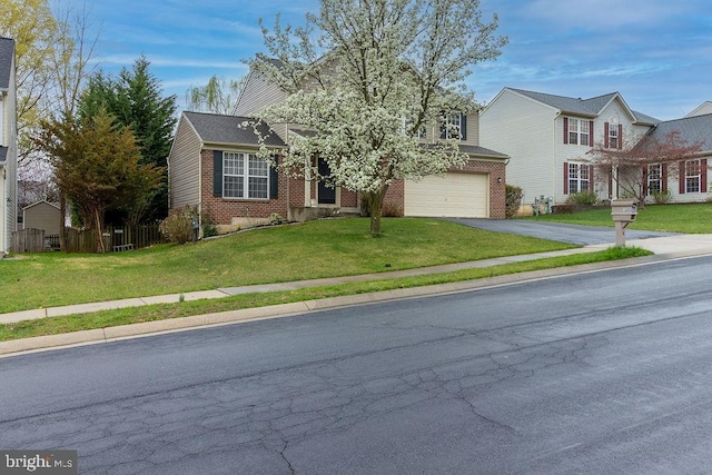traditional-style house with brick siding, a front lawn, fence, and aphalt driveway