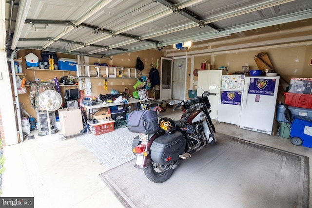 garage with a garage door opener and freestanding refrigerator