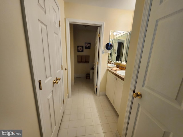 bathroom with vanity, baseboards, and tile patterned flooring