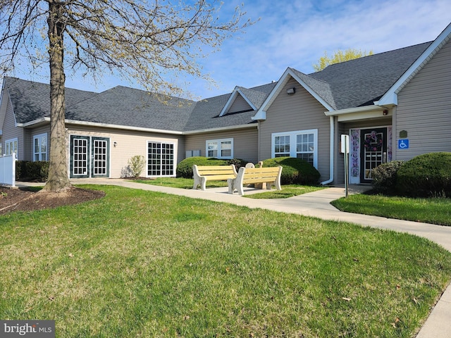 single story home featuring a front yard, french doors, and a shingled roof