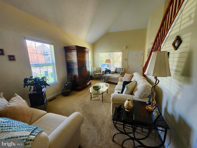 carpeted living area with visible vents, baseboards, vaulted ceiling, and a wealth of natural light