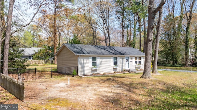 view of front of home featuring roof with shingles, fence, and a front yard