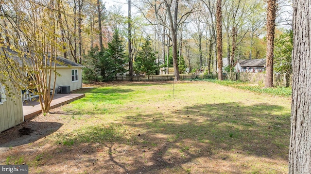 view of yard featuring central AC, a deck, and fence