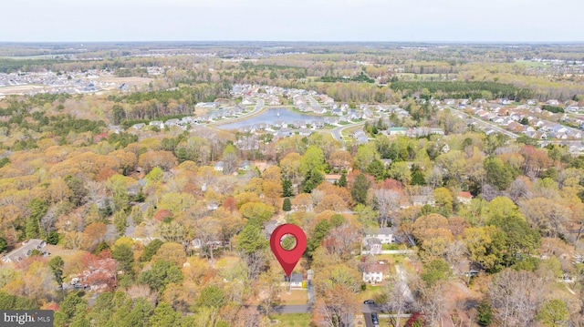 drone / aerial view with a wooded view and a water view