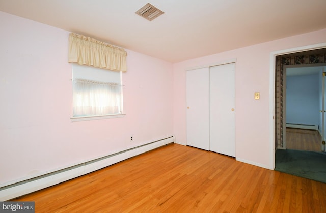 745 Champlain Dr, King Of Prussia, PA 19406 - unfurnished bedroom with baseboard heating, a closet, visible vents, and light wood-style flooring