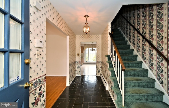 745 Champlain Dr, King Of Prussia, PA 19406 - foyer entrance featuring a baseboard heating unit, an inviting chandelier, wallpapered walls, stairway, and stone finish floor
